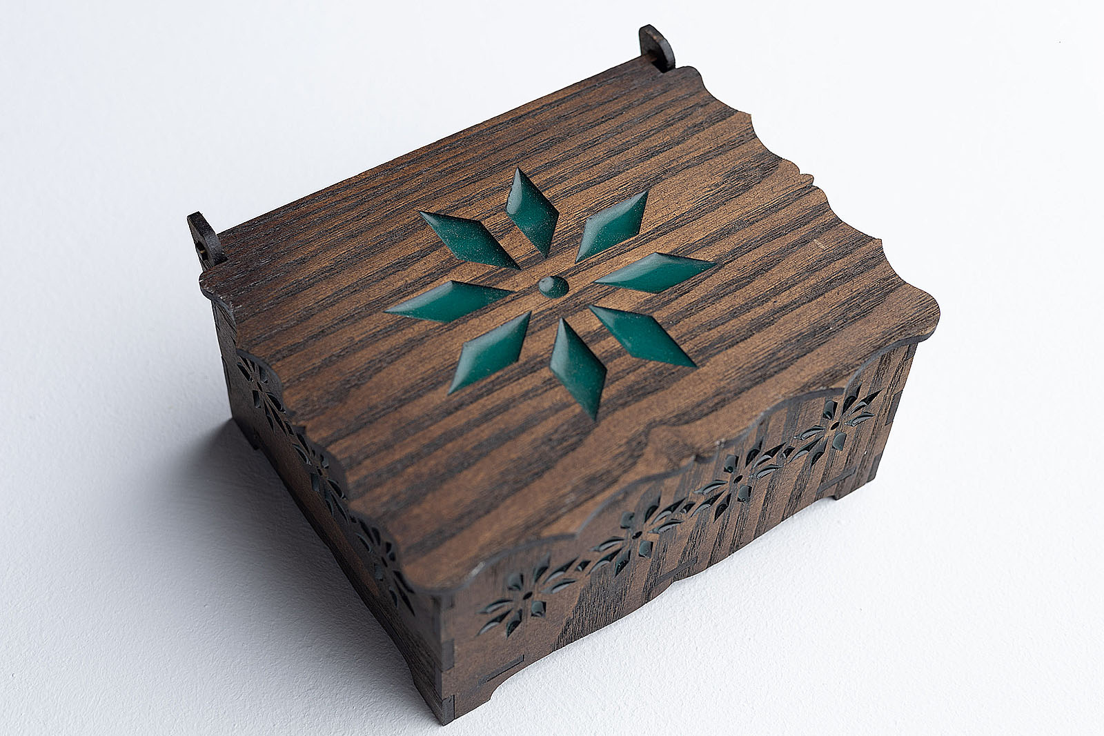 Vista superior de la tapa del joyero de madera con estrella de resina epoxi verde esmeralda.