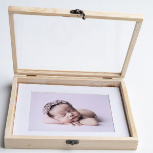 Caja madera pino tapa metacrilato abierta mostrando foto bebé fondo.