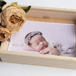 Caja de madera con tapa transparente de metacrilato conteniendo foto de bebé recién nacido.