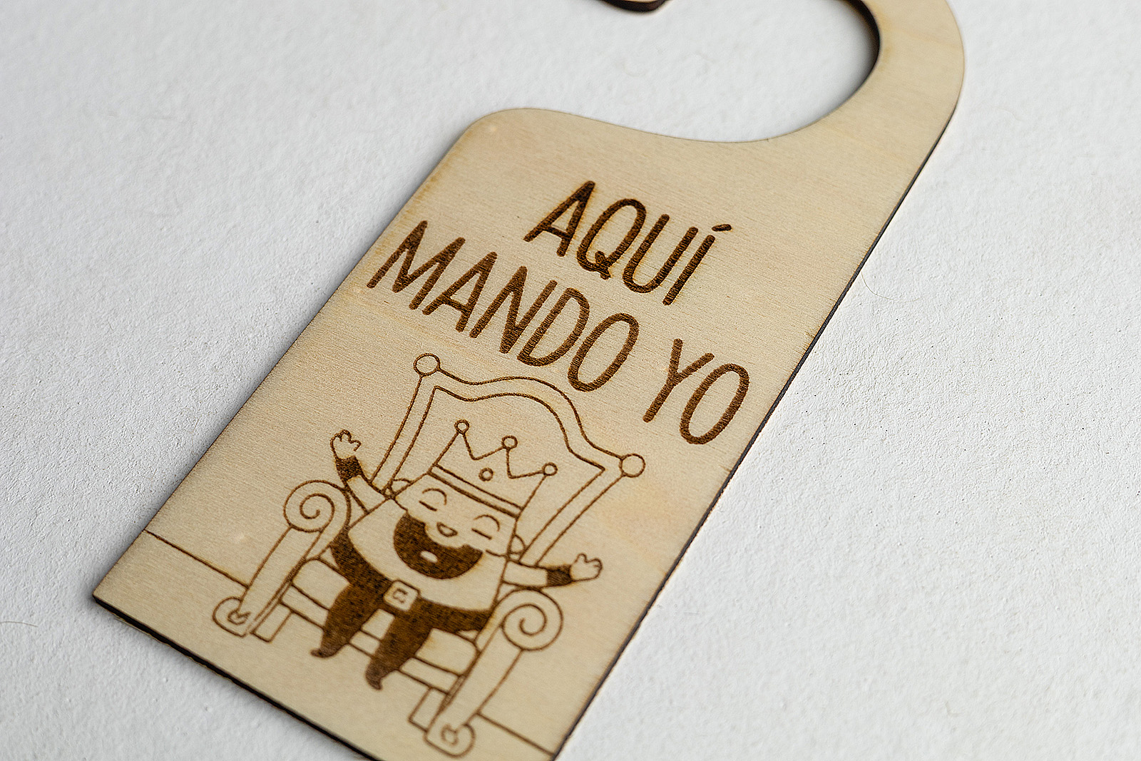 Colgador de puerta infantil con frase Aquí Mando Yo aislado en fondo blanco.