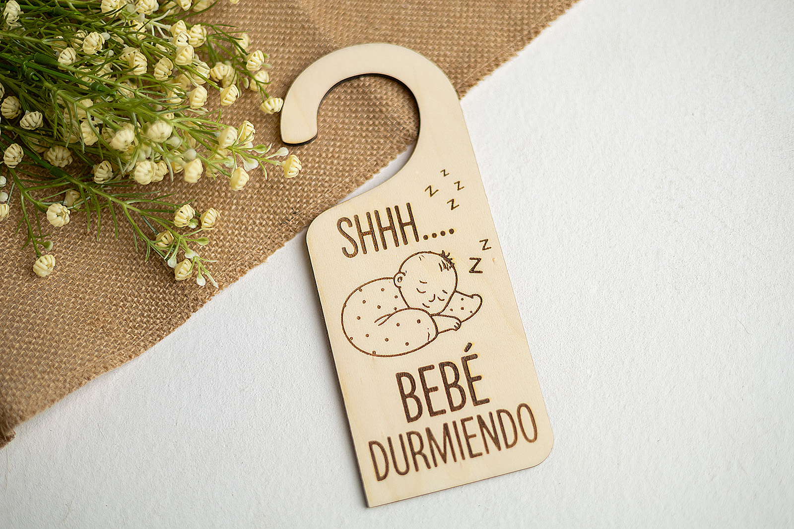 Colgador de puerta de madera Bebé Durmiendo sobre fondo de decoración natural.