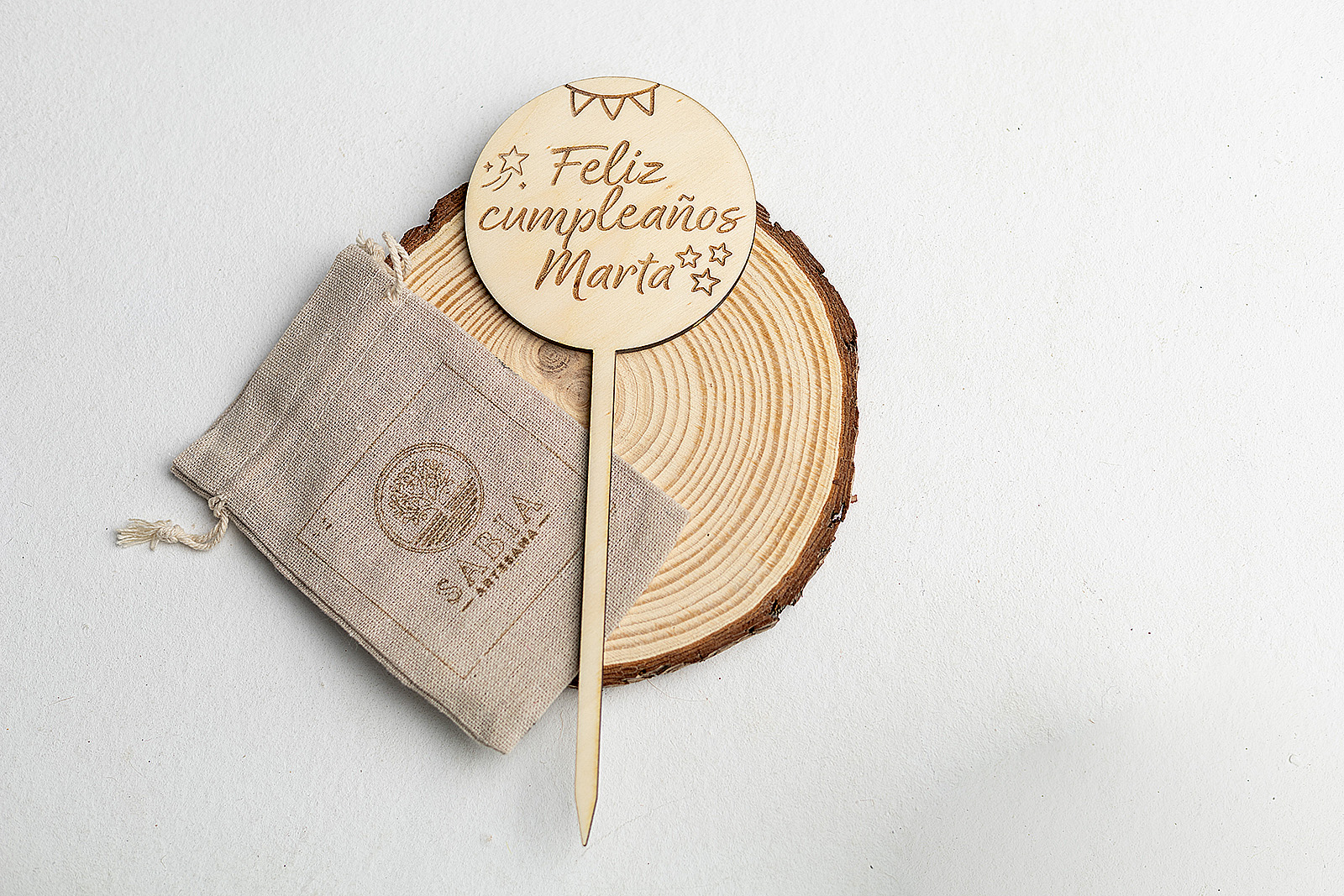 Topper de tarta de madera circular grabado con Feliz Cumpleaños Marta y estrellas.