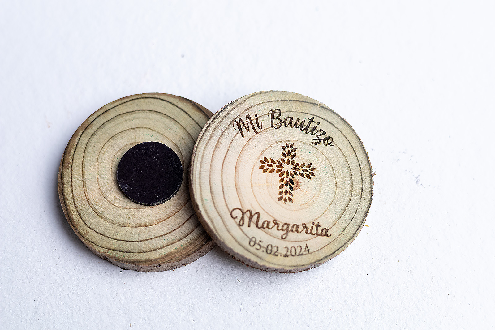 Vista frontal y trasera de imanes de madera rústica para bautizo con cruz de flores grabada.