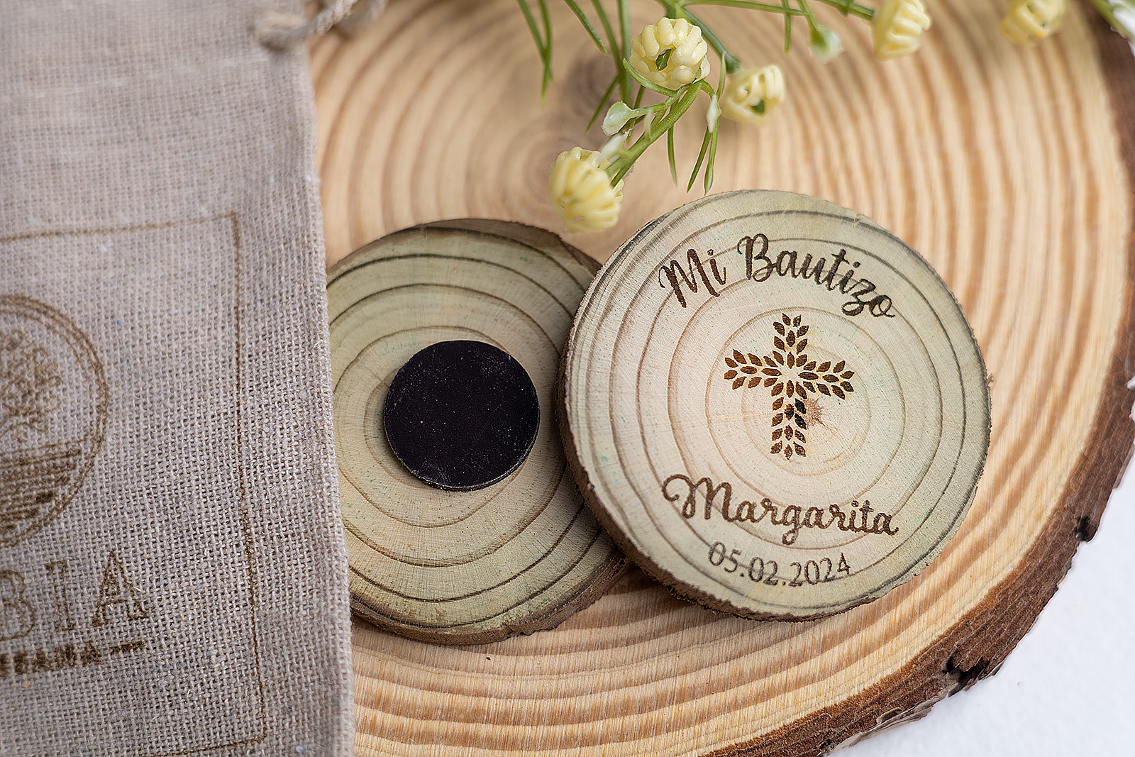 Grupo de imanes de bautizo de madera natural modelo Cruz Floral sobre base de madera decorativa.