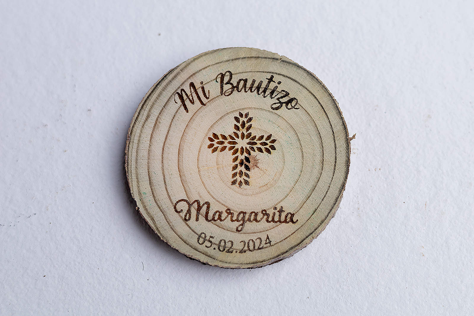 Vista superior de detalle de bautizo rústico en madera modelo Cruz Floral personalizado con fecha.