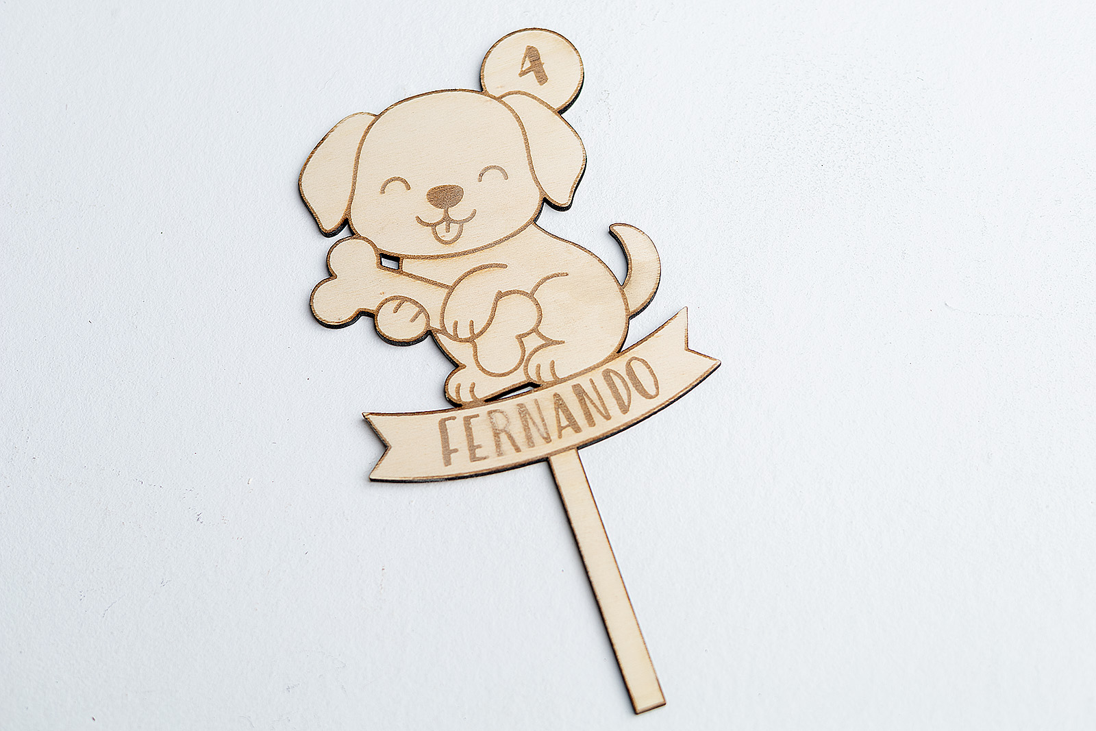 Adorno de madera para tarta infantil con diseño de perro y personalización de nombre y edad, perfecto para fiestas de cumpleaños temáticas.