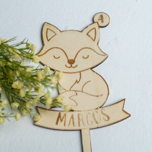 Topper de madera para tarta de cumpleaños con diseño de zorro durmiendo, personalizado con el nombre Marcos y el número 4, presentado con decoración floral.
