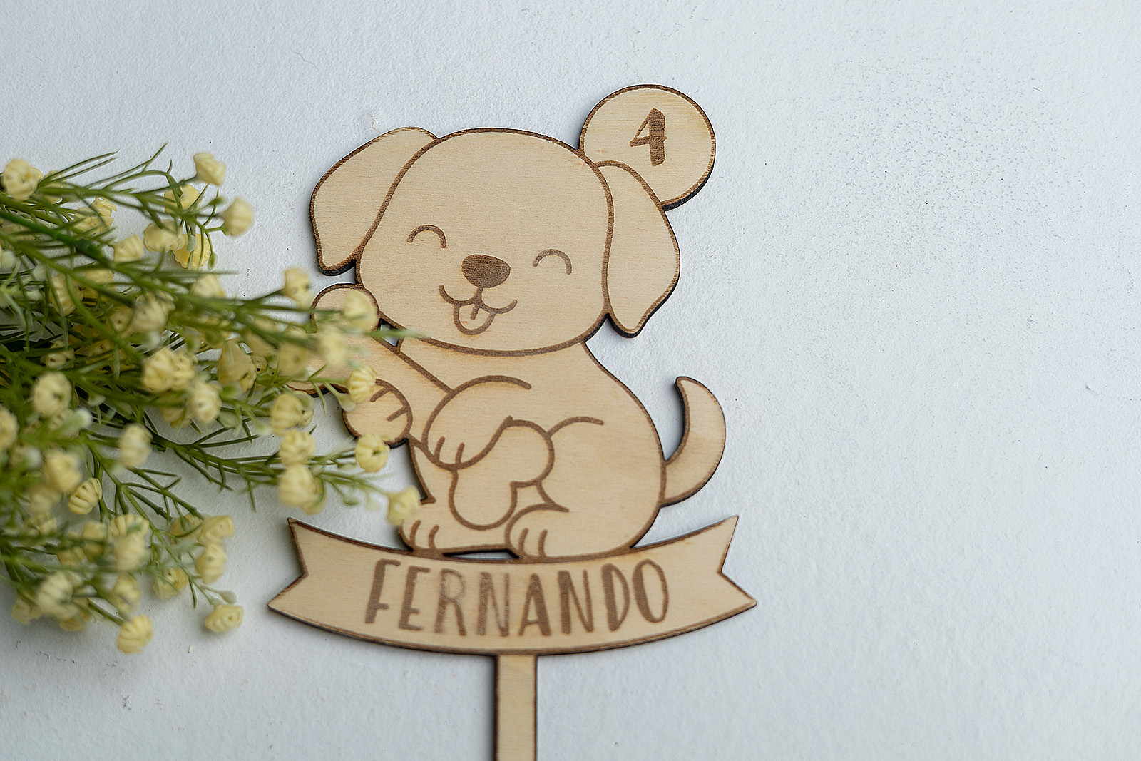 Topper de madera para tarta de cumpleaños con diseño de cachorro feliz con hueso, personalizado con el nombre Fernando y el número 4, rodeado de flores.