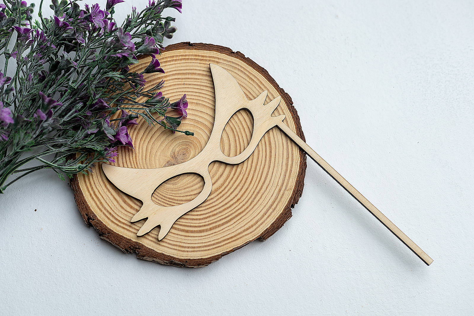 Antifaz de gato de madera con varilla, presentado con decoración floral y rústica, ideal como accesorio divertido para photocall.