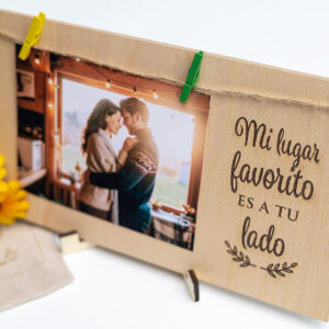 Portafotos de madera para regalar a tu pareja, decorado con flores amarillas y una foto romántica colgada con pinzas.