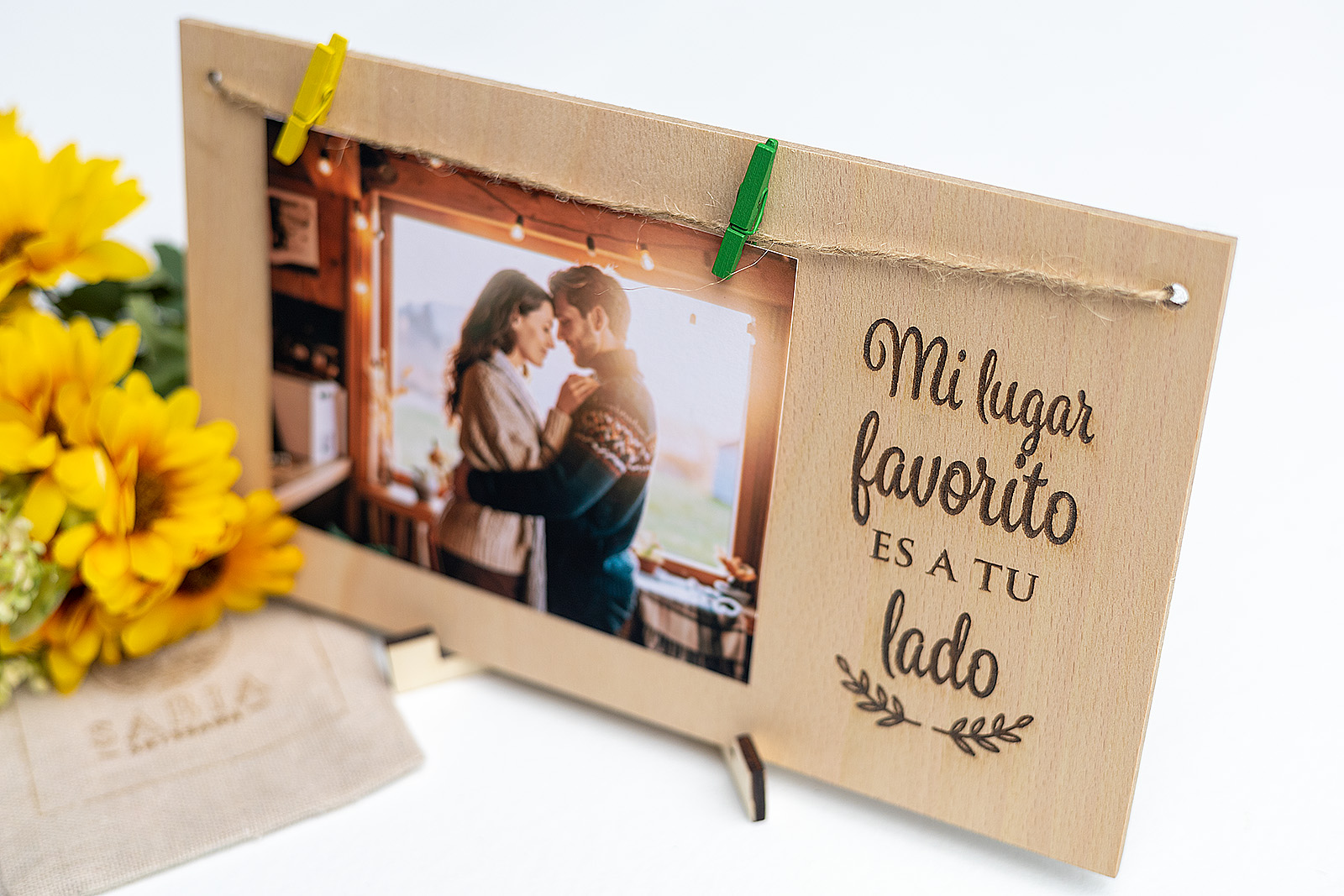 Portafotos de madera para regalar a tu pareja, decorado con flores amarillas y una foto romántica colgada con pinzas.
