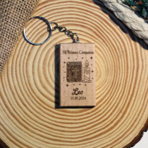 Llavero de comunión personalizado de madera con biblia y vela, grabado con el nombre Leo, sobre una rodaja de madera