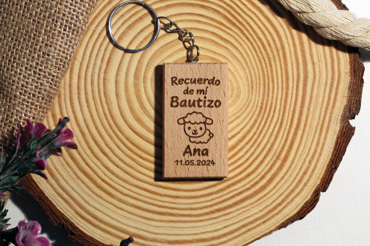 Llavero rectangular de madera personalizado para bautizo con diseño de oveja y fecha, presentado en estilo rústico sobre madera natural.