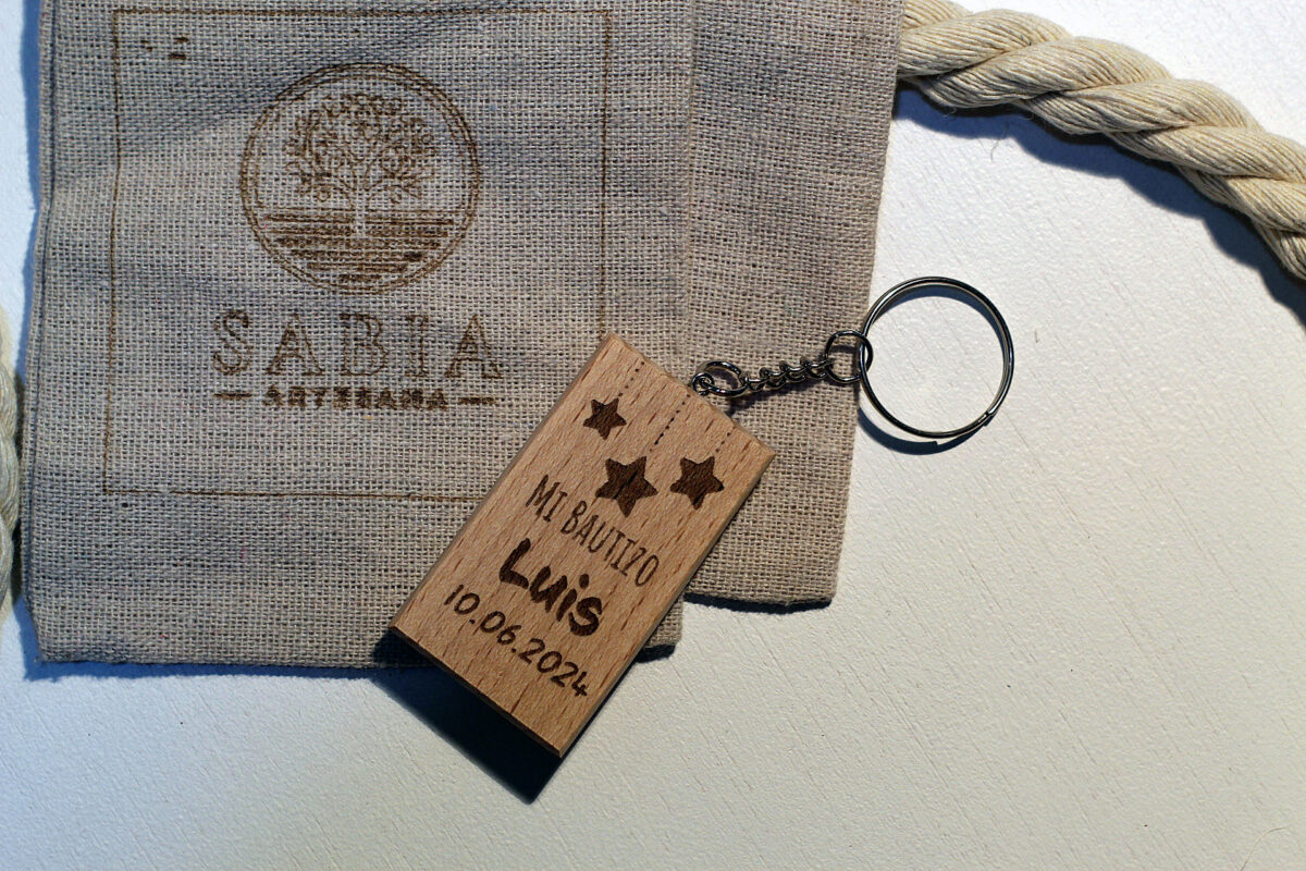 Llavero de madera personalizado para bautizo con diseño de estrellas colgantes y nombre Luis, presentado con una bolsa de tela artesanal.