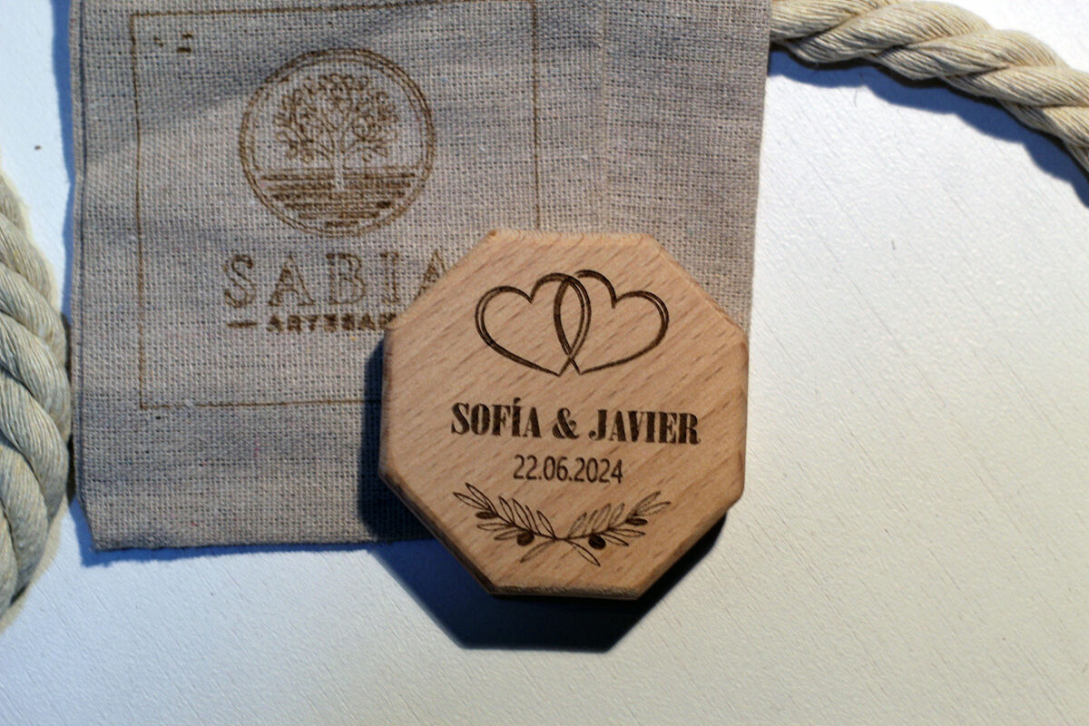 Abrebotellas magnético de madera para boda, personalizado con nombres y fecha, presentado junto a su bolsa de regalo de lino.