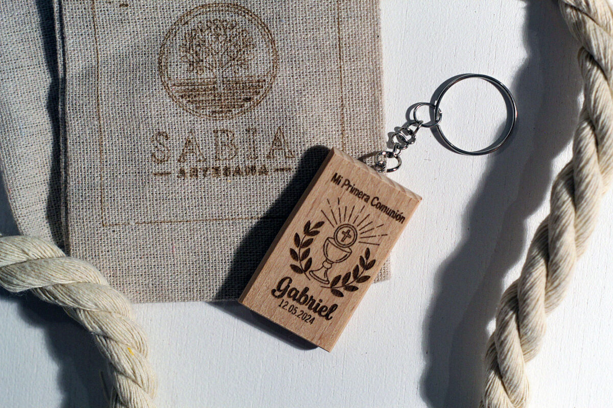Recuerdo de Primera Comunión: Llavero de madera rectangular personalizado con un cáliz grabado y el nombre Gabriel, presentado con su bolsa de lino.