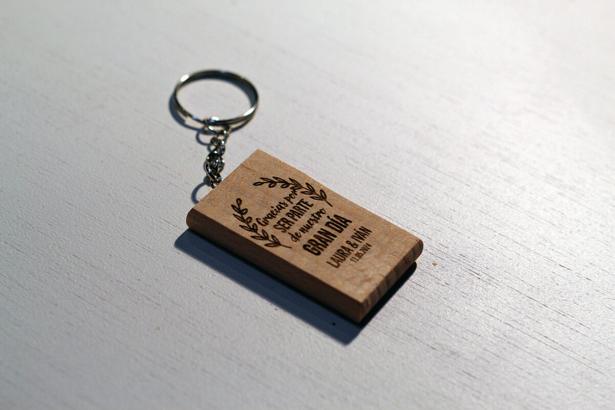 Llavero de madera rectangular personalizado para boda con la frase "Gracias por ser parte de nuestro Gran Día" y los nombres Laura e Iván grabados.